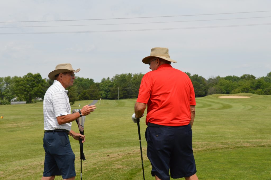 two men talking on golf course